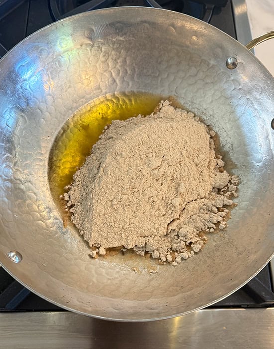 atta with ghee in a brass kadai