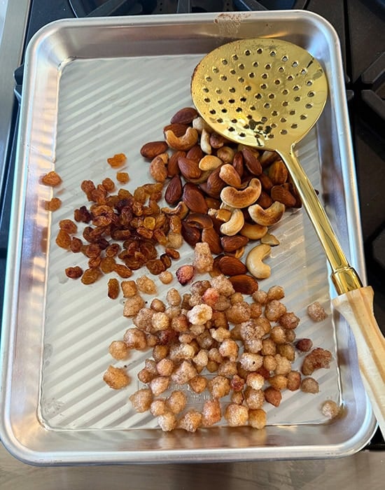 fried nuts and raisins placed on a baking sheet