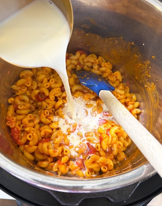 milk being added to pasta in the instant pot