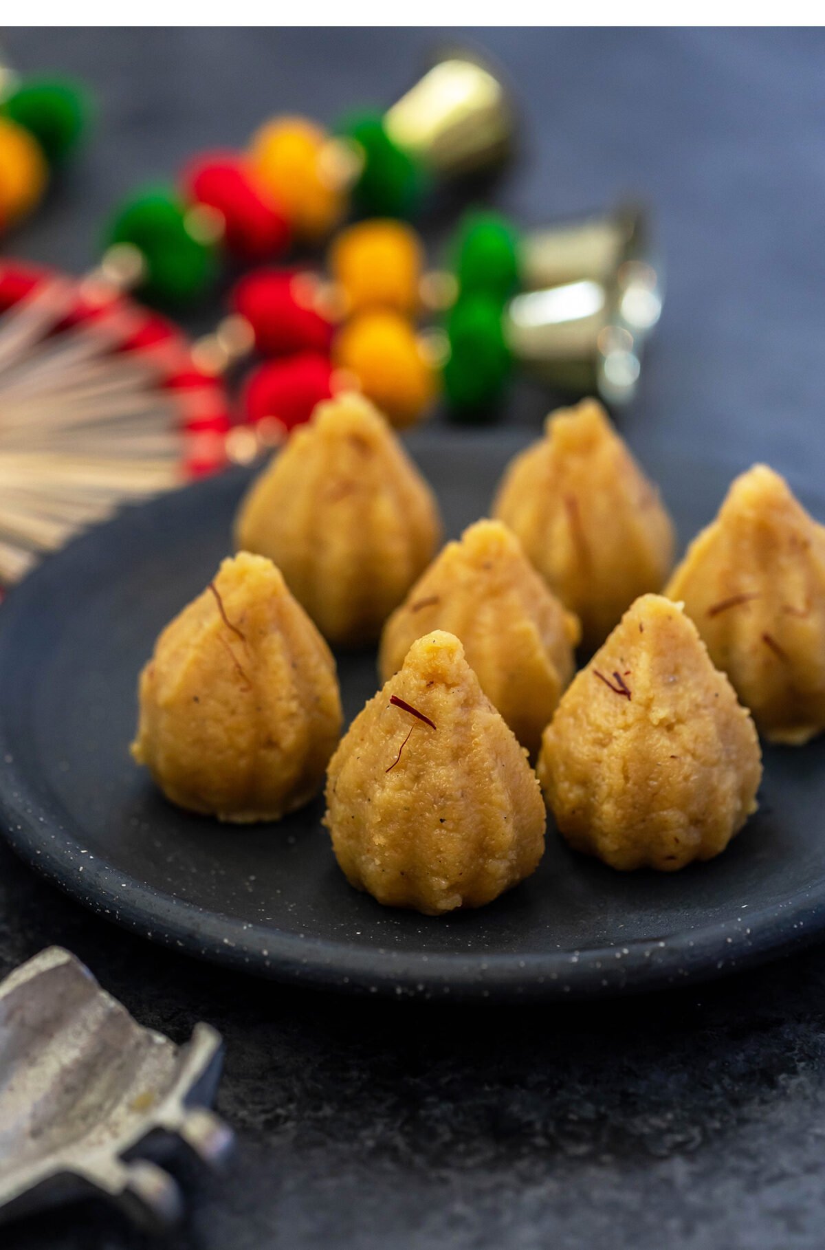 7 mawa modak arranged in a black round plate