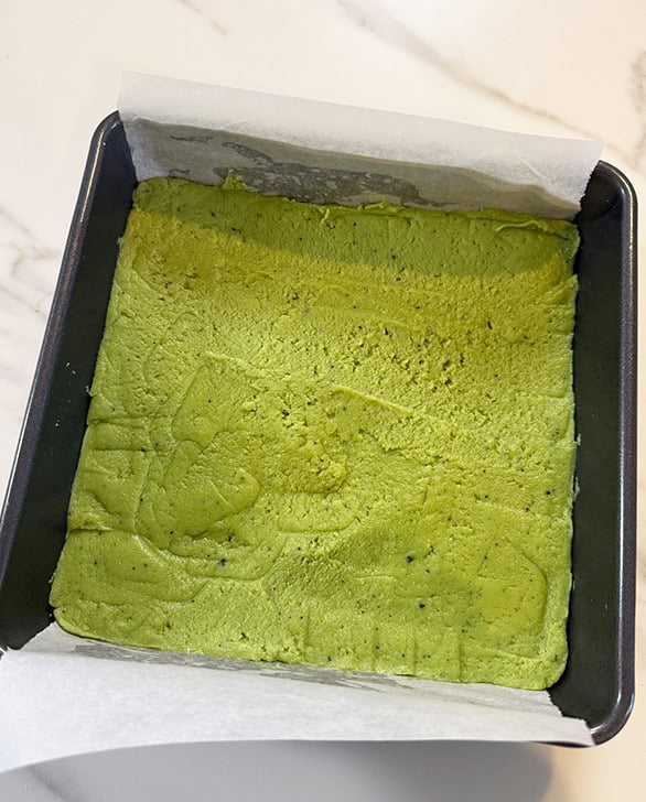 matcha burfi mixture in a square pan