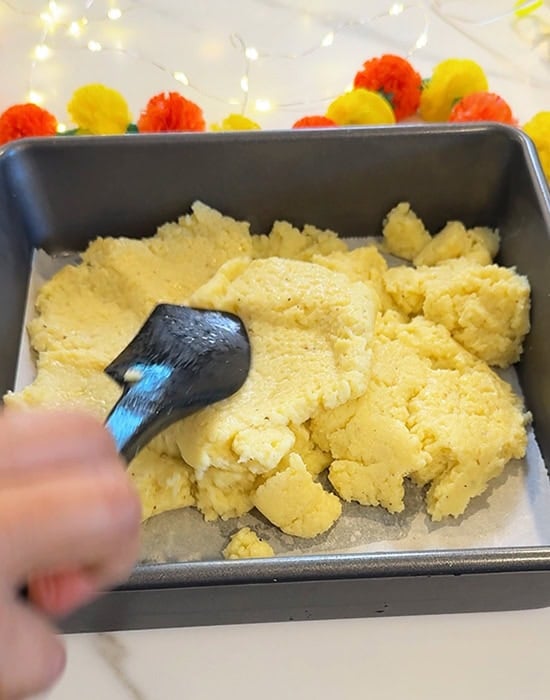 cooked burfi mixture in a square pan
