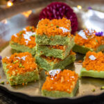 matcha burfis topped with motichoor stacked together