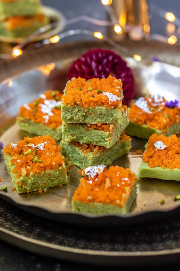 matcha burfis topped with motichoor stacked together