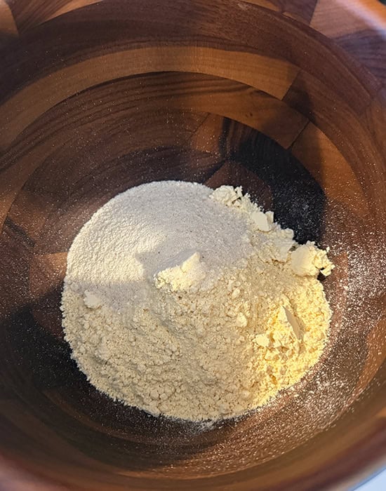 a wooden bowl with different types of flour mixed together