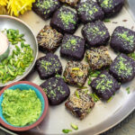 date bites arranged on a golden plate with flowers in the background
