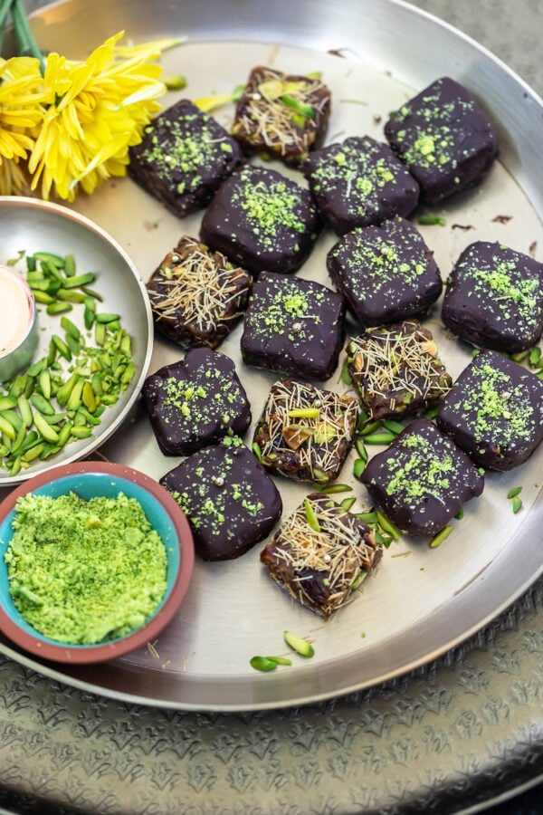 date bites arranged on a golden plate with flowers in the background