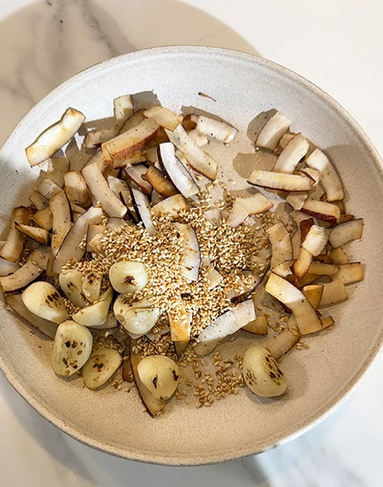 roasted garlic, sesame seeds and coconut in a white bowl