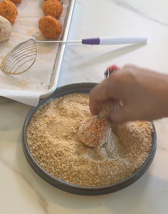 rolling arancini in breadcrumbs
