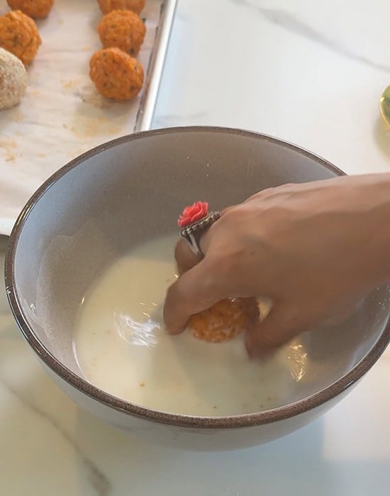 dipping arancini in corn flour slurry