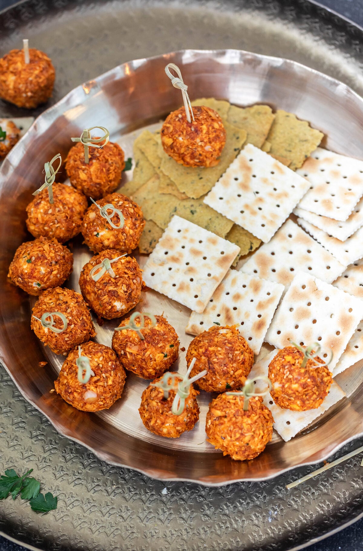 truffles with little skewers placed in a tray with crackers on the side