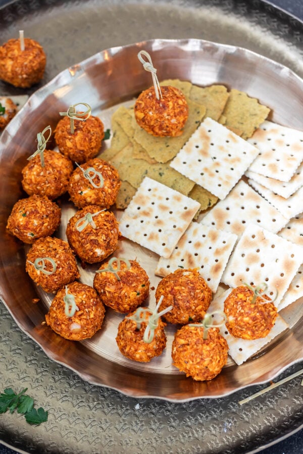 truffles with little skewers placed in a tray with crackers on the side
