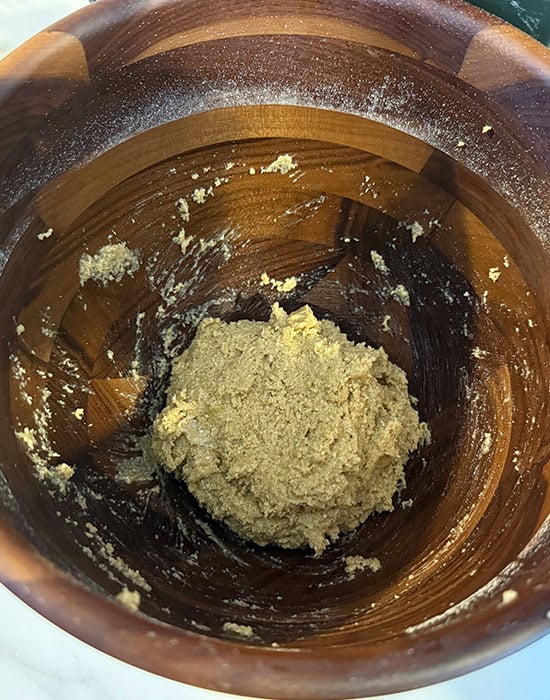 wet looking dough in a wooden bowl