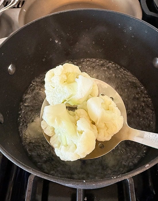 spatula showing par boiled cauliflower florets