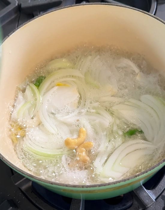 sliced onions, chilies boiling in a pot of water