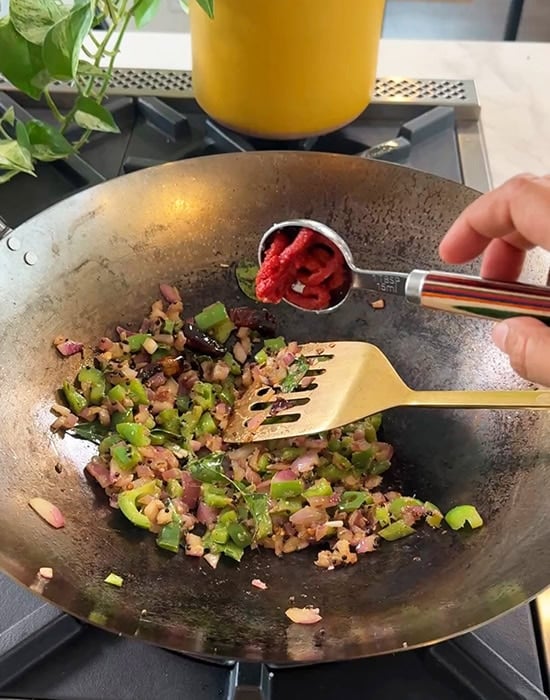 tomato paste being added to wok