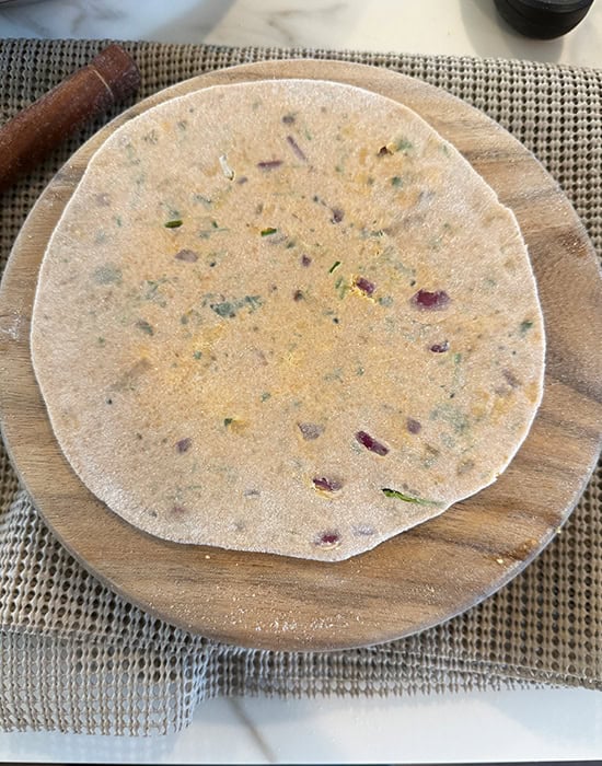rolled sattu paratha on a wooden board