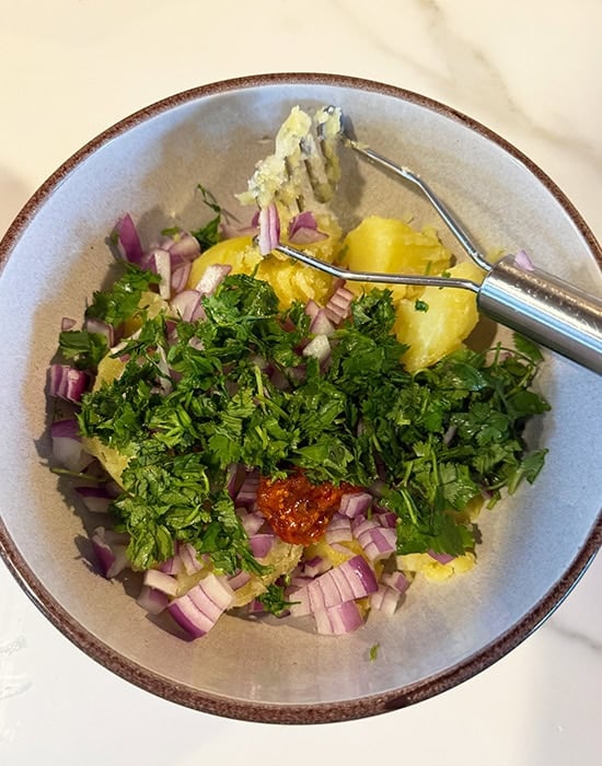 potatoes with cilantro, onion, chilies in a bowl
