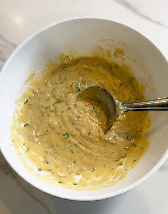 ground dal batter in a white bowl with steel spatula