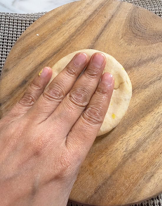 hand flattening a rolled dough