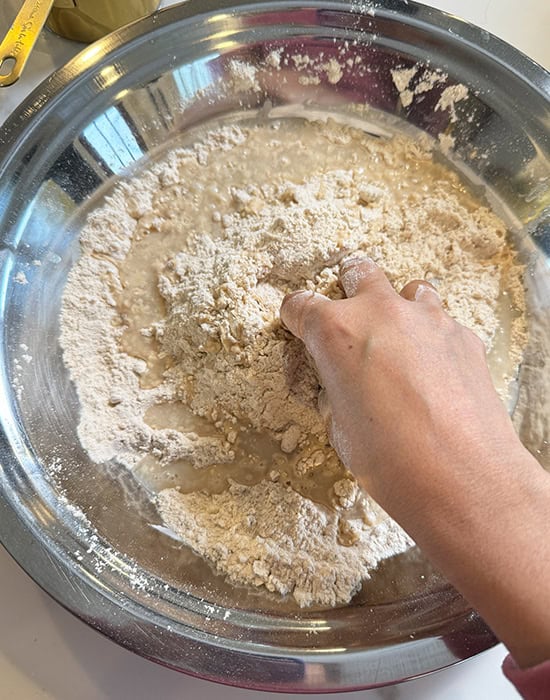 mixing flour with oil in a big steel plate