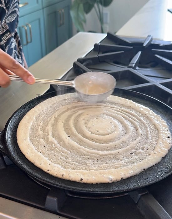 dosa batter spread on a tawa