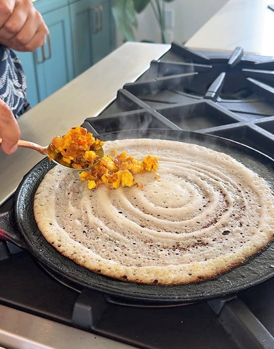 adding paneer filling to dosa