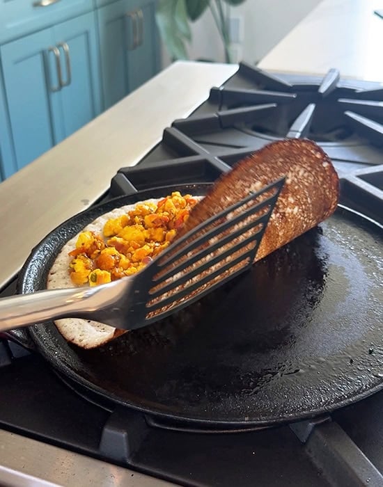 spatula lifting dosa to close it on a tawa