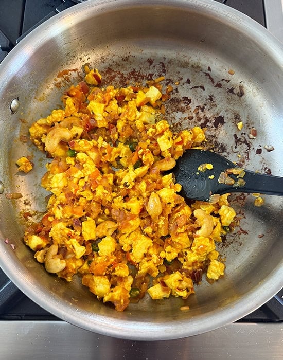 paneer cubes with onions tomatoes in a steel pan