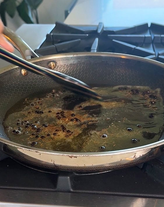 cumin seeds peppercorn being cooked in ghee