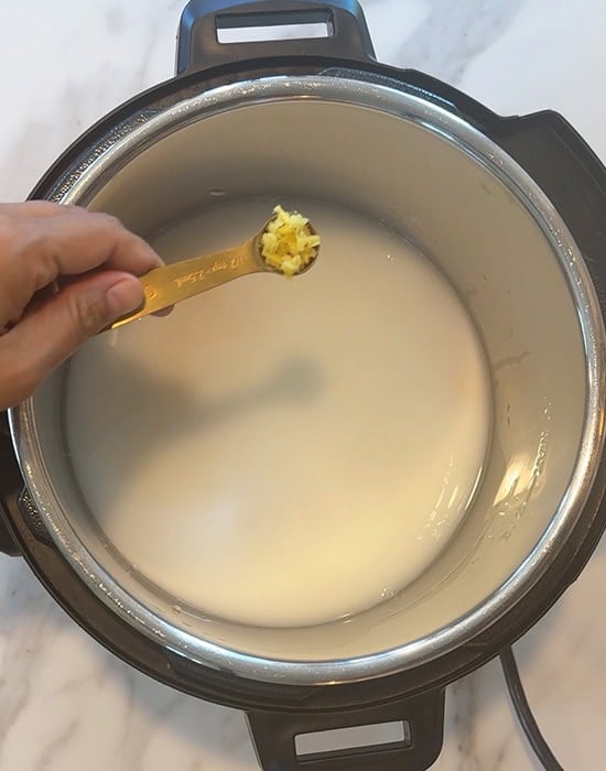 spoon adding ginger to pot