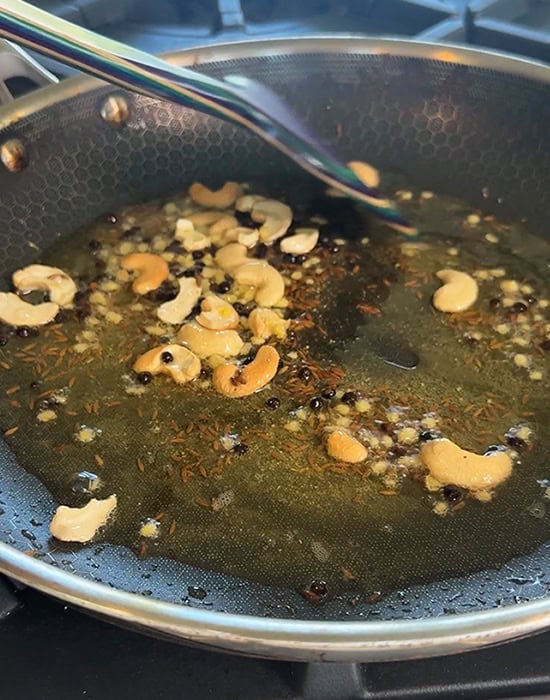 spatula stirring spices cashews in oil