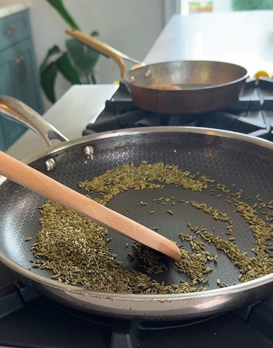 toasting fennel seeds in a pan