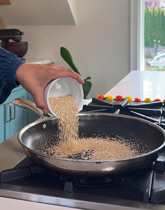 adding quinoa to a pan