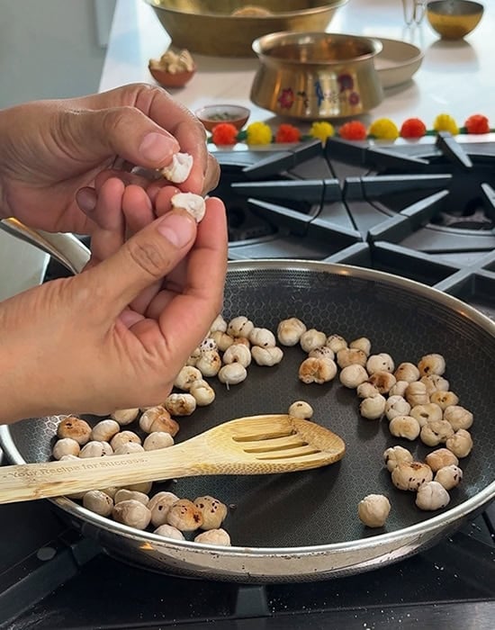 hand breaking a makhana to show the texture