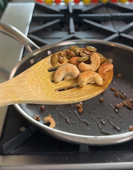wooden spatula showing roasted nuts