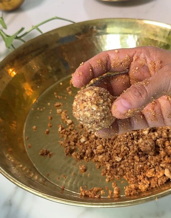hand showing a round ladoo