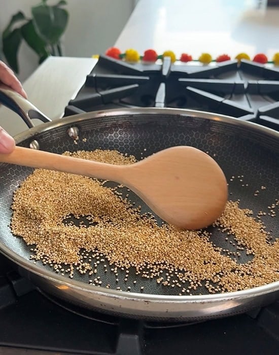 wooden spatula sauteing quinoa in a pan