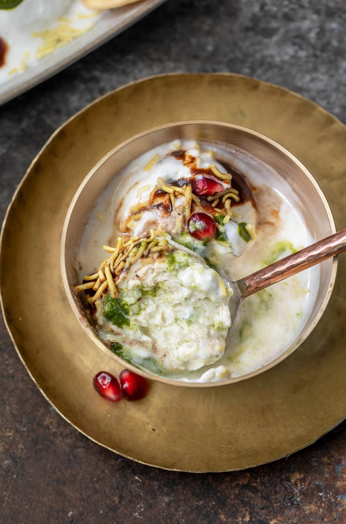 rasgulla chaat topped with pomegranate served in a copper bowl