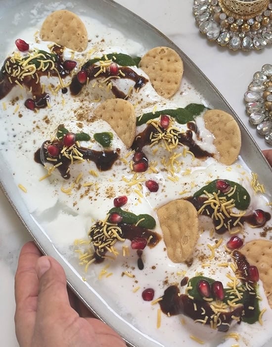 chaat on a platter topped with papdi, chutneys